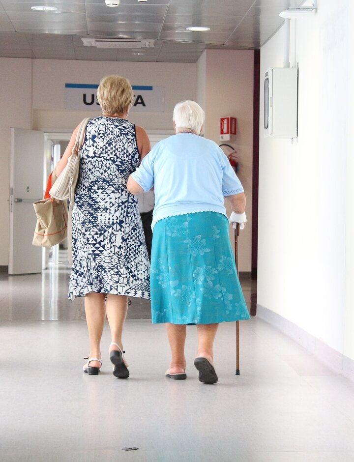 Zwei Frauen gehen über einen Krankenhausflur.