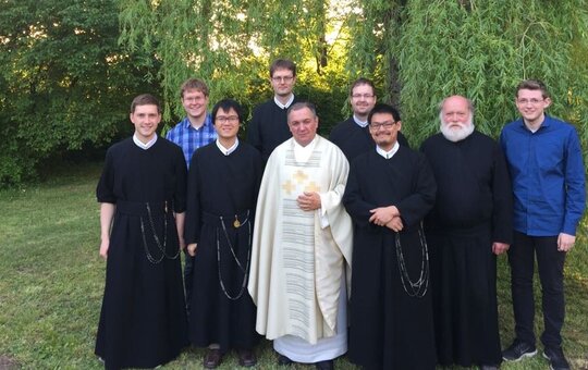 Eine Gruppe von Mönchen des Redemptoristenklosters Würzburg auf einer Wiese 